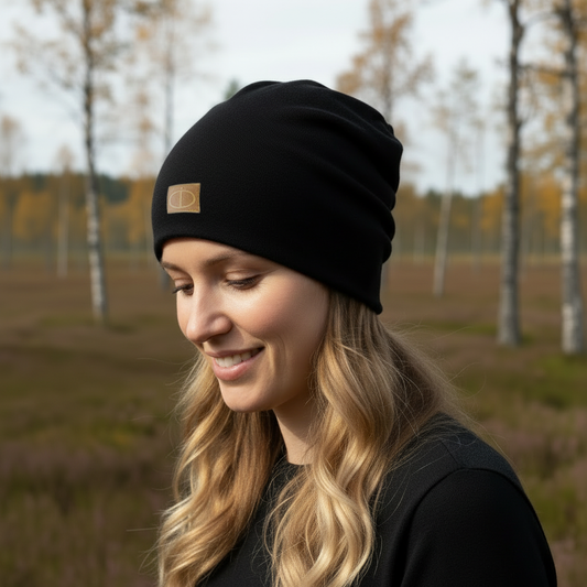 Musta merinovillapipo naisen päässä syksyisessä maisemassa, luonnollinen valo. Damaski, merinovilla.
